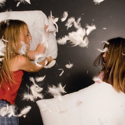 zwei Kinder liefern sich eine Kissenschlacht